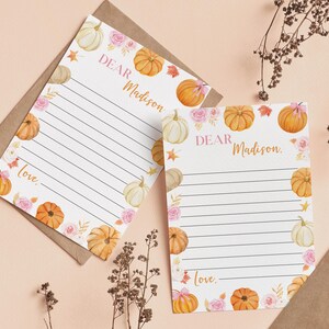 Puede incluir: Dos hojas de papel de carta blancas con l&iacute;neas negras horizontales, con ilustraciones en acuarela de calabazas naranjas y blancas, rosas rosadas y hojas de oto&ntilde;o. El texto "Dear Madison" y "love." est&aacute; impreso en una fuente dorada.