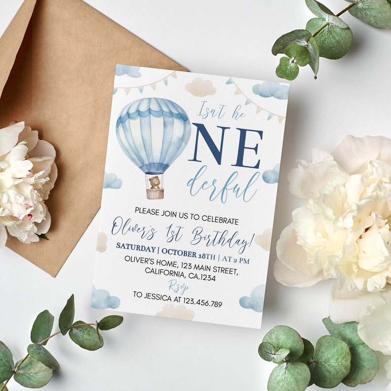 Pu&ograve; includere: Un biglietto d'invito di compleanno rettangolare con un'illustrazione ad acquerello di una mongolfiera blu che trasporta un orsacchiotto. Il testo recita: Isn't he ONEderful, PLEASE JOIN US TO CELEBRATE Oliver's 1st Birthday! SATURDAY | OCTOBER 18TH | AT 2 PM, OLIVER'S HOME, 123 MAIN STREET, CALIFORNIA, CA.1234, RSVP TO JESSICA AT 123.456.789.