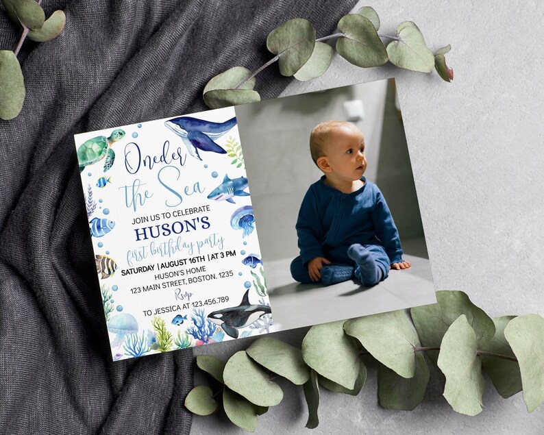 May include: A blue and white invitation card with a watercolor illustration of sea creatures, including a whale, turtle, fish, and jellyfish. The text on the card reads "Oneder the Sea" and "Huson's First Birthday Party".