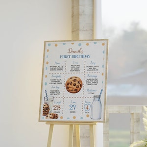 May include: A blue and brown printable first birthday sign for a boy named Daniel. The sign features a cookie graphic and lists the child's age, weight, height, and favorite foods, toys, and songs.