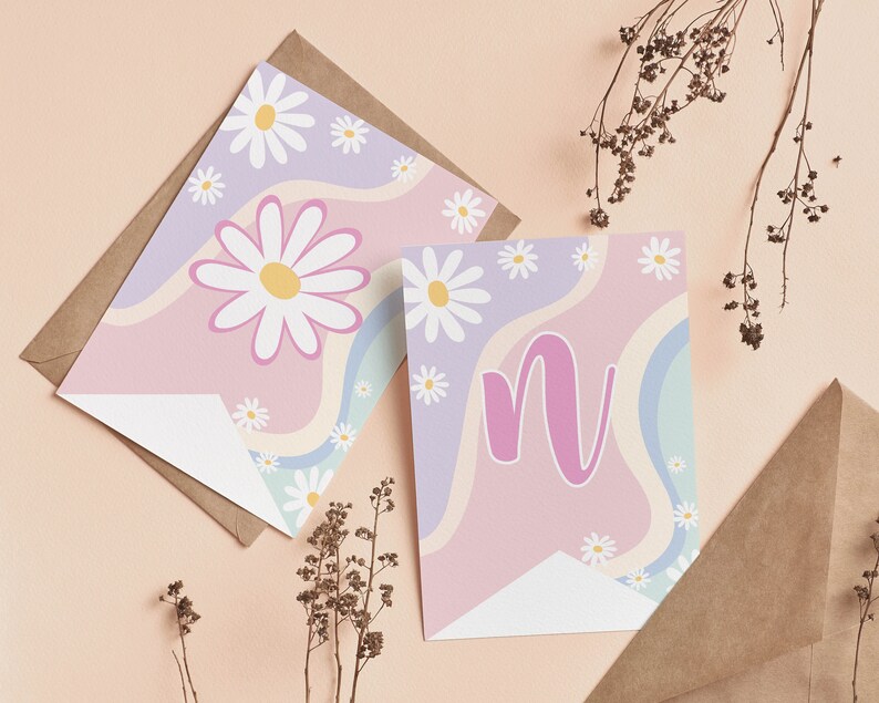 Op de afbeelding: Twee rechthoekige kaarten met een golvende pastelachtergrond in lavendel, roze en lichtblauw, versierd met witte madeliefjes. De ene kaart toont een grote madelief, terwijl de andere in het midden een gestileerde roze letter n heeft.