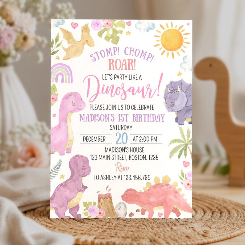 May include: A rectangular birthday invitation card featuring watercolor illustrations of colorful dinosaurs, a sun, clouds, and flowers. The text reads: STOMP! CHOMP! ROAR! LET'S PARTY LIKE A DINOSAUR! PLEASE JOIN US TO CELEBRATE MADISON'S 1ST BIRTHDAY.