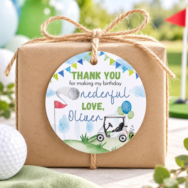 May include: A round white gift tag tied to a brown paper package with twine. The tag features a golf theme with a golf cart, a golf ball on a tee, and blue and green bunting. Text reads: THANK YOU for making my birthday onederful LOVE, Oliver.