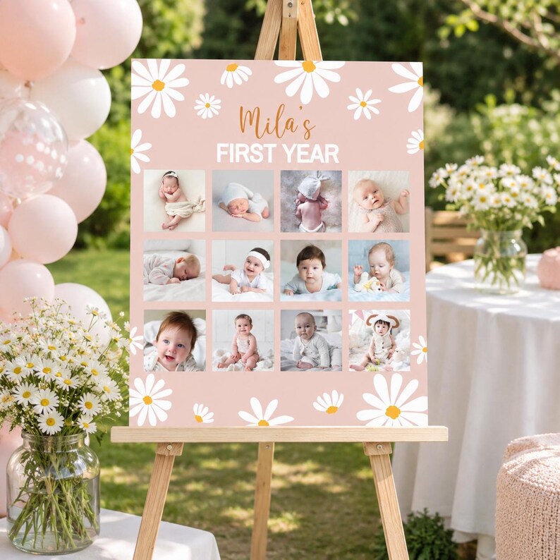 May include: A rectangular pink sign featuring white daisy illustrations and the text "Mila's FIRST YEAR" in white and orange. The sign displays a grid of twelve individual photographs of a baby at different stages of their first year.