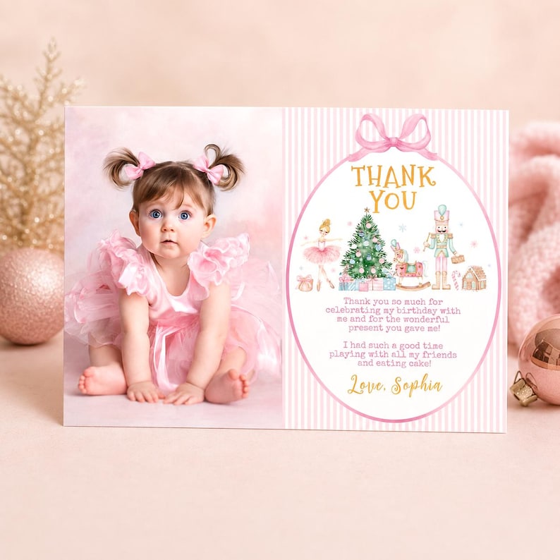 May include: A rectangular thank you card featuring a photograph of a toddler in a pink ruffled dress with matching hair bows on the left. The right side has a pink striped background with a gold oval frame containing a Christmas-themed illustration.