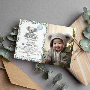 Puede incluir: Una tarjeta de invitaci&oacute;n de cumplea&ntilde;os rectangular con una ilustraci&oacute;n de koala en acuarela, un globo azul claro con el n&uacute;mero uno y follaje de eucalipto verde. El texto dice: TIME TO CELEBRATE! Lucas IS TURNING ONE!