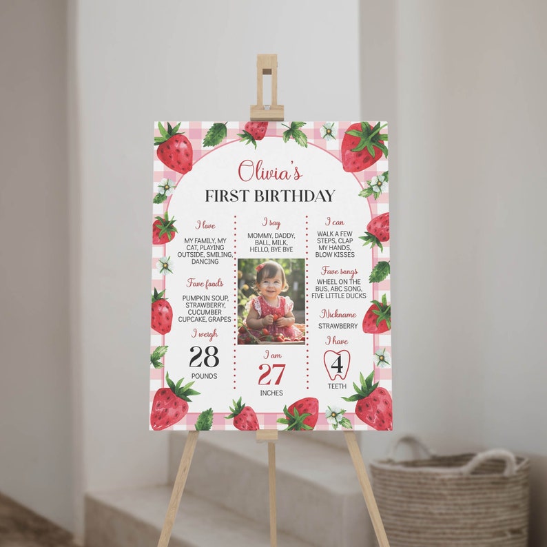 May include: A pink and white gingham background with a strawberry theme. A photo of a baby girl is in the center of the poster. The poster lists the baby's age, weight, height, favorite foods, songs, and activities. The text reads "Olivia's First Birthday".