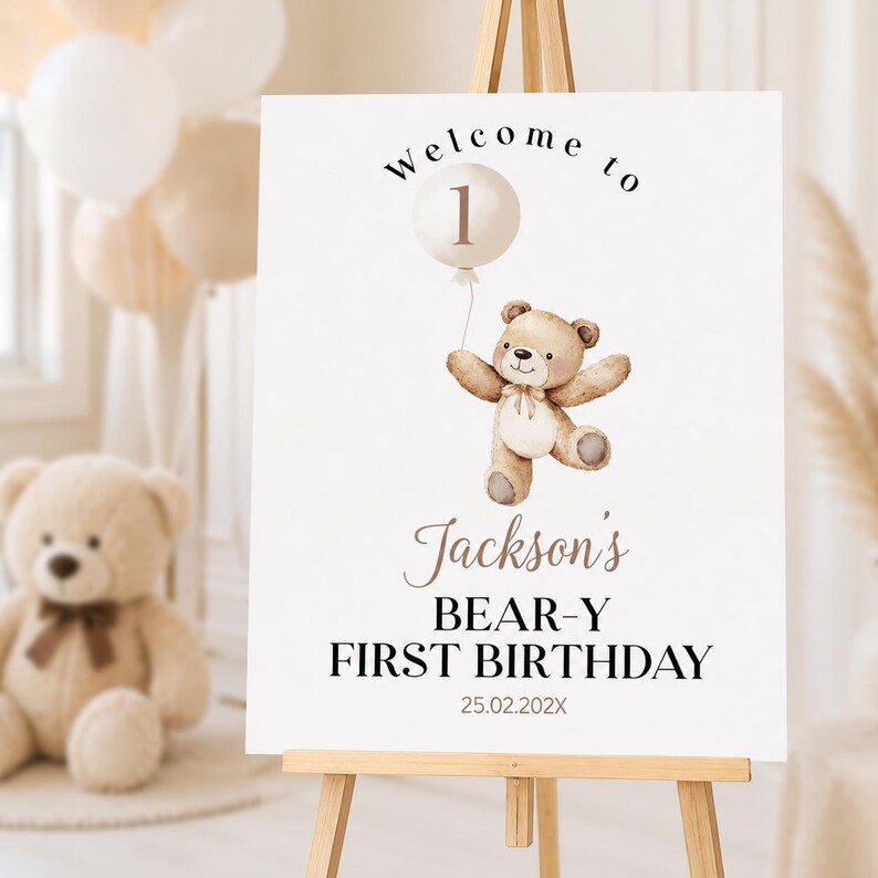 May include: A white rectangular birthday welcome sign featuring a watercolor illustration of a brown teddy bear holding a white balloon with the number 1. The text reads Welcome to Jackson's BEAR-Y FIRST BIRTHDAY and the date 25.02.202X.