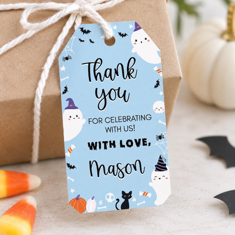 Pu&ograve; includere: Un'etichetta regalo rettangolare azzurra con angoli superiori arrotondati, decorata con fantasmi bianchi che indossano cappelli viola e neri, gatti neri, pipistrelli, ragni e zucche. Il testo recita: Thank you FOR CELEBRATING WITH US! WITH LOVE, Mason.