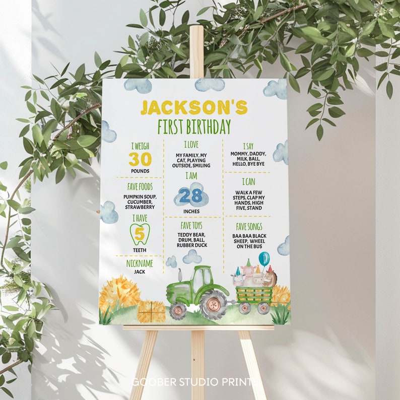 May include: A rectangular birthday milestone sign for Jackson's first birthday featuring watercolor illustrations of a green tractor, hay bales, and farm animals. The white sign includes yellow and green text detailing weight, height, and favorite things.