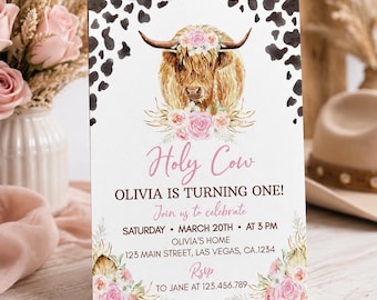 Può includere: Un biglietto d'invito rettangolare per compleanno con una mucca Highland ad acquerello con una corona di fiori rosa, circondato da un bordo con macchie di mucca. Il testo riporta Holy Cow, OLIVIA IS TURNING ONE! e i dettagli dell'evento.