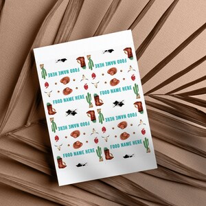 K&ouml;nnte beinhalten: Ein rechteckiges Blatt Papier mit einem sich wiederholenden Muster aus Western-Illustrationen, darunter braune Cowboystiefel, beige H&uuml;te, gr&uuml;ne Kakteen, Kuhsch&auml;del, rote Bandanas und schwarz-wei&szlig;e Kuhflecken, mit dem Text FOOD NAME HERE.