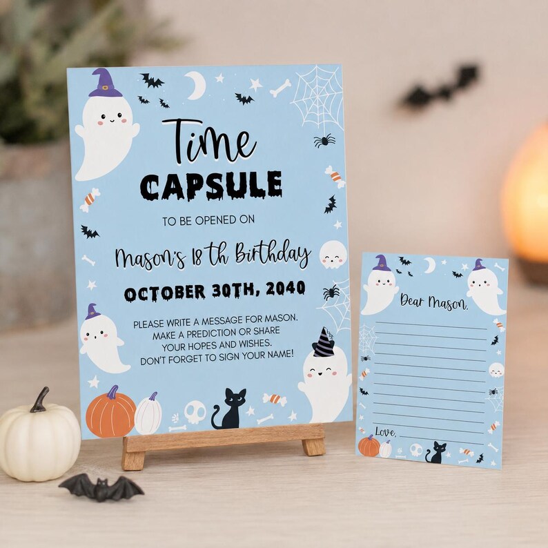 May include: A light blue time capsule sign and matching card featuring ghosts, pumpkins, black cats, and bats. The sign reads: Time CAPSULE TO BE OPENED ON Mason's 18th Birthday OCTOBER 30TH, 2040. PLEASE WRITE A MESSAGE FOR MASON.