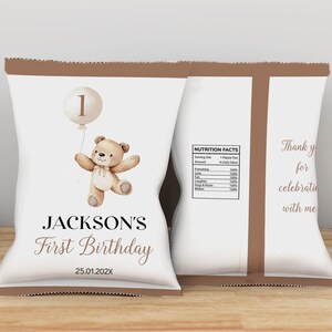 May include: Brown and white personalized chip bag with a teddy bear and balloon illustration. The bag says "Jackson's First Birthday 25.01.202X".