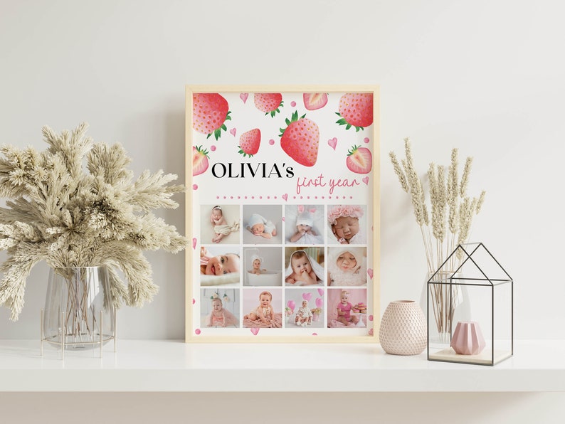 K&ouml;nnte beinhalten: Ein rechteckiger gerahmter Druck mit einem Erdbeermotiv und dem Text "OLIVIA'S first year" oben. Unter dem Text zeigt ein Raster aus zw&ouml;lf einzelnen Fotos ein Baby in verschiedenen Phasen seines ersten Lebensjahres.