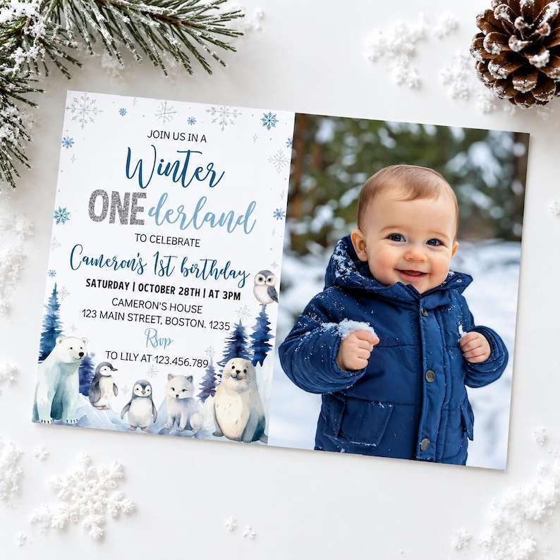 May include: A rectangular birthday invitation card featuring a photo of a child in a navy blue winter jacket on the right. The left side displays text reading Winter ONEderland, Cameron's 1st birthday, and details, with illustrations of a polar bear, penguins, a fox, a seal, and an owl.