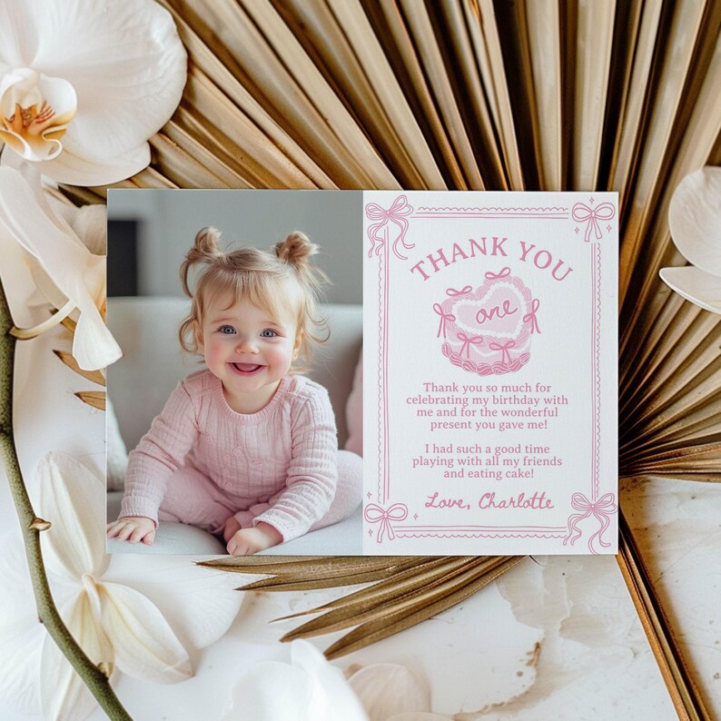 Pu&ograve; includere: Un biglietto di ringraziamento rosa e bianco con una foto di una bambina. Il biglietto dice "Grazie" e "uno" in un cuore rosa. Il testo dice "Grazie mille per aver festeggiato il mio compleanno con me e per il meraviglioso regalo che mi hai fatto! Mi sono divertita un mondo a giocare con tutti i miei amici e a mangiare la torta! Con affetto, Charlotte."