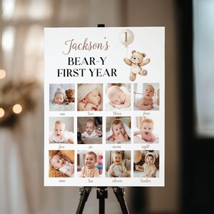 May include: A white poster with the text "Jackson's BEAR-Y FIRST YEAR" and a teddy bear holding a balloon. The poster has 12 photo squares with pictures of a baby boy at different ages.