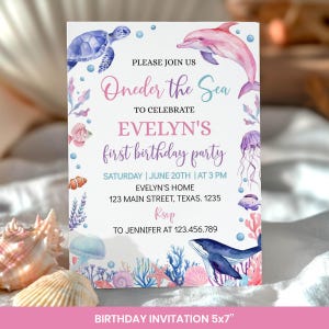 May include: A rectangular birthday invitation card featuring watercolor illustrations of a blue sea turtle, a pink dolphin, a blue whale, jellyfish, and coral. The text reads: PLEASE JOIN US Oneder the Sea TO CELEBRATE EVELYN'S first birthday party.
