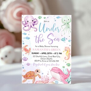 May include: A rectangular baby shower invitation card featuring watercolor illustrations of a purple octopus, green jellyfish, orange crab, yellow seahorse, brown sea turtle, and pink whale. The text reads Under the Sea for a Baby Shower honoring SAMANTHA GREEN.