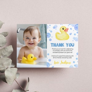 K&ouml;nnte beinhalten: Eine Dankeskarte mit einem Foto eines kleinen Jungen in der Badewanne mit einer gelben Gummi-Ente. Die Karte hat einen blauen und wei&szlig;en Hintergrund mit einer gelben Gummi-Ente und blauen Blasen. Der Text auf der Karte lautet "Danke. Vielen Dank, dass Sie meinen Geburtstag mit mir gefeiert haben und f&uuml;r das wundervolle Geschenk, das Sie mir gemacht haben! Ich hatte so viel Spa&szlig; beim Spielen mit all meinen Freunden und beim Kuchen essen! Liebe Gr&uuml;&szlig;e, Jackson."
