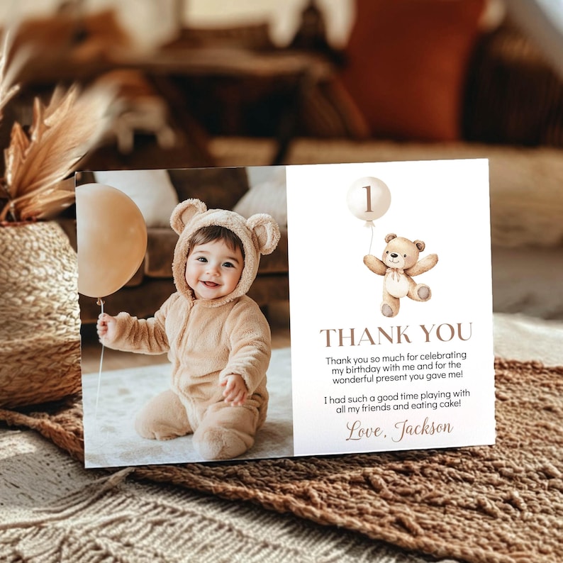 May include: A rectangular thank you card featuring a photo of a child in a tan bear-ear onesie holding a beige balloon. The right side displays a watercolor teddy bear with a balloon, the number 1, and the text: THANK YOU, Thank you so much for celebrating my birthday with me and for the wonderful present you gave me! I had such a good time playing with all my friends and eating cake! Love, Jackson.