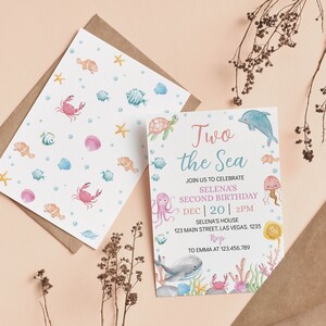 May include: A blue and pink invitation card with a watercolor illustration of a sea turtle, octopus, whale, crab, and jellyfish. The text on the card reads "Two the Sea" and "Selena's Second Birthday".