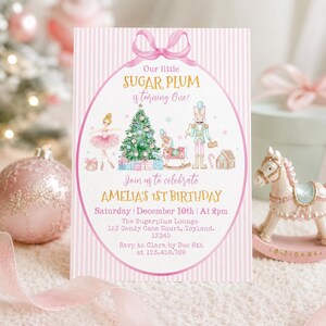 May include: A rectangular birthday invitation card with a pink and white striped background featuring a pink bow at the top. The text reads Our little SUGAR PLUM is turning One! Join us to celebrate AMELIA'S 1ST BIRTHDAY, Saturday December 10th at 2pm.