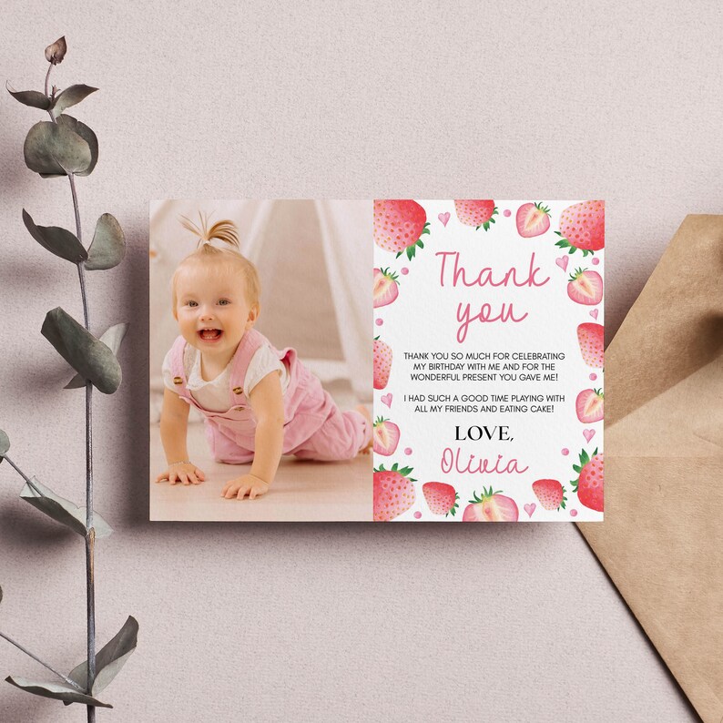 May include: A rectangular thank you card featuring a photograph of a smiling child on the left and a white background with watercolor strawberry illustrations and pink hearts on the right. The text reads Thank you, followed by a message and the name Olivia.