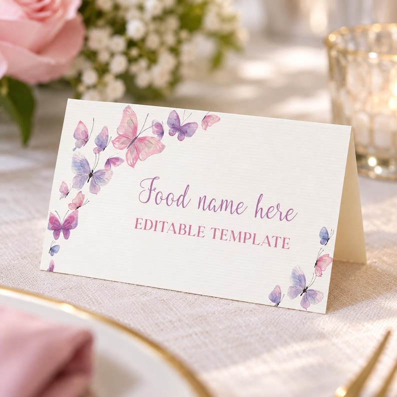 Peut inclure: Un marque-place en papier cartonn&eacute; blanc pli&eacute; orn&eacute; d'aquarelles de papillons dans des tons roses et violets. Le texte indique Food name here et EDITABLE TEMPLATE dans une police scripte et sans-serif violette, dispos&eacute; sur les bords.