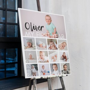 Pu&ograve; includere: Una bacheca fotografica rettangolare intitolata Oliver MY FIRST YEAR con una grande immagine di un bambino in alto e dodici foto mensili pi&ugrave; piccole numerate disposte in una griglia. Il design utilizza testo bianco e un layout pulito.