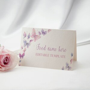 Peut inclure: Une carte pli&eacute;e de couleur cr&egrave;me orn&eacute;e d'aquarelles de papillons dans des tons roses et violets, avec le texte imprim&eacute; Food name here et EDITABLE TEMPLATE, accompagn&eacute;e d'une rose rose p&acirc;le plac&eacute;e sur la gauche de la carte.