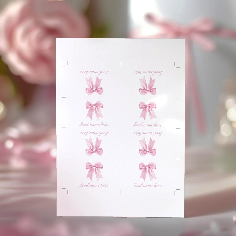 May include: A white rectangular sheet of paper featuring eight individual sections arranged in two columns. Each section displays a watercolor-style illustration of a light pink bow and the placeholder text Food name here in a cursive font.