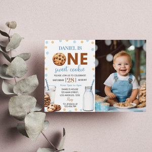 Pu&ograve; includere: Invito di compleanno blu e oro con una foto di un bambino che tiene un biscotto. L'invito dice "Daniel ha un anno, un dolce biscotto" e include i dettagli della festa, tra cui la data, l'ora e il luogo.