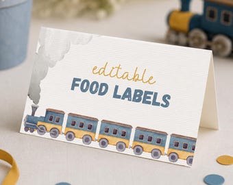 May include: A folded white card featuring a watercolor illustration of a blue and yellow train with smoke. The text reads editable FOOD LABELS in yellow and blue. The card has a textured surface and is designed for use as a food label.