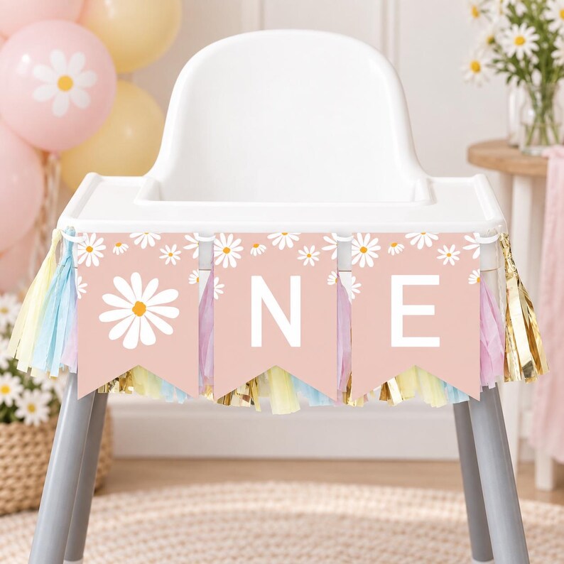 K&ouml;nnte beinhalten: Ein Hochstuhl-Banner mit drei altrosa Wimpeln, die mit wei&szlig;en G&auml;nsebl&uuml;mchenmustern und den wei&szlig;en Buchstaben O, N und E bedruckt sind. Das Banner ist mit einer Fransenborte aus pastellfarbenen und metallisch goldenen Quasten verziert.
