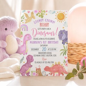 May include: A rectangular birthday invitation card featuring watercolor illustrations of dinosaurs, a sun, a rainbow, and flowers. The text reads: STOMP! CHOMP! ROAR! LET'S PARTY LIKE A DINOSAUR! PLEASE JOIN US TO CELEBRATE MADISON'S 1ST BIRTHDAY SATURDAY DECEMBER 20 AT 2:00 PM MADISON'S HOUSE 123 MAIN STREET, BOSTON. 1235 RSVP TO ASHLEY AT 123.456.789.