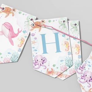 Peut inclure: Une banni&egrave;re color&eacute;e sur le th&egrave;me de l'oc&eacute;an avec la lettre "H" au centre. La banni&egrave;re pr&eacute;sente des illustrations de cr&eacute;atures marines comme des baleines, des pieuvres, des hippocampes et des tortues. La banni&egrave;re est parfaite pour une f&ecirc;te pr&eacute;natale ou un anniversaire.