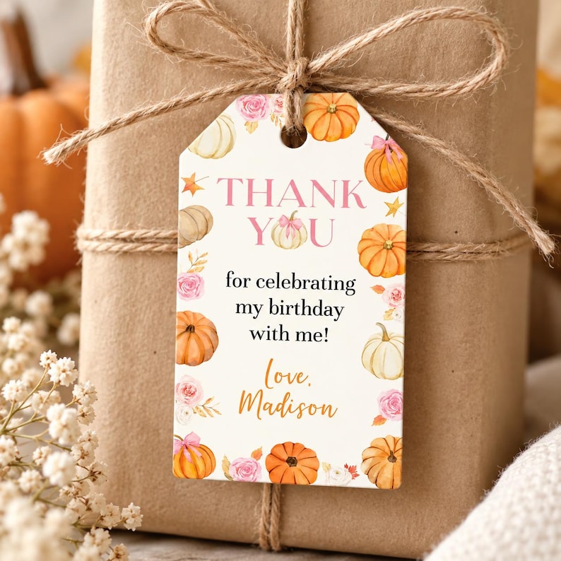 May include: A rectangular gift tag with a white background featuring orange and cream pumpkins, pink roses, and gold stars. The text reads: THANK YOU for celebrating my birthday with me! Love, Madison. The tag is tied with brown twine to a brown package.