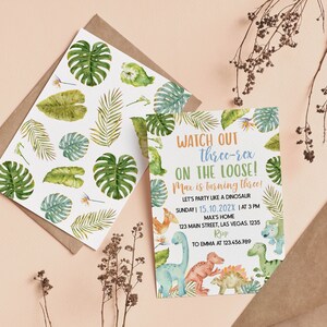 May include: A rectangular invitation card and a matching envelope liner featuring watercolor illustrations of green tropical leaves and colorful dinosaurs. The text reads: WATCH OUT three-rex ON THE LOOSE! Max is turning three! LET'S PARTY LIKE A DINOSAUR.
