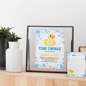 May include: A time capsule card with a yellow rubber ducky and blue bubbles. The card says "Time Capsule" and "To be opened when Jackson turns 18". There is a separate card with the text "Dear Jackson" and a blank space for writing a message.