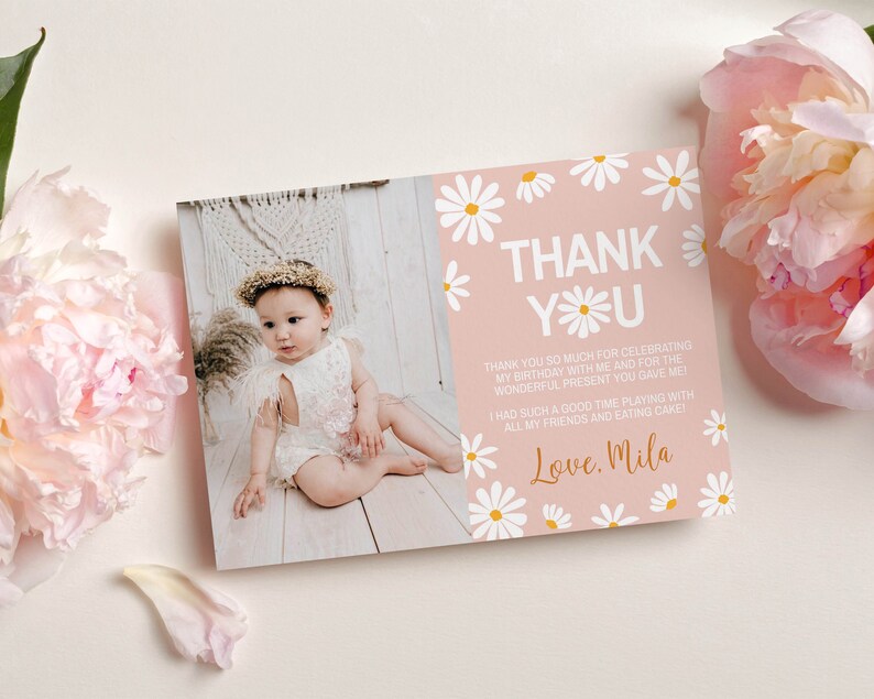 May include: Pink thank you card with white daisies and yellow centers. The card has the text "THANK YOU" in white with a daisy in the "O". The text below reads "Thank you so much for celebrating my birthday with me and for the wonderful present you gave me. I had such a good time playing with all my friends and eating cake! Love. Mila"