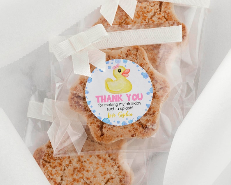 Pu&ograve; includere: Biscotti a forma di stella confezionati in sacchetti di plastica trasparente con fiocchi di nastro bianco. Ogni sacchetto presenta un adesivo circolare con una papera di gomma gialla, bolle blu e il testo: THANK YOU for making my birthday such a splash! Love Sophia.