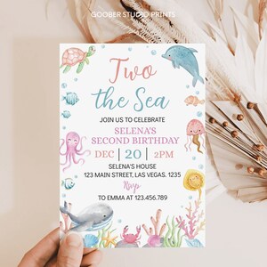 May include: A light blue and pink invitation card with the text "Two the Sea" and "Selena's Second Birthday" with a date and time of December 20th at 2 PM. The card features a variety of sea creatures including a turtle, dolphin, octopus, jellyfish, and a whale.