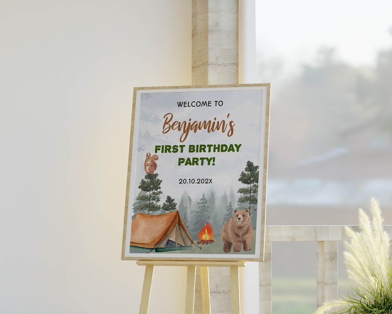Op de afbeelding: Een rechthoekig bord op een houten ezel met de tekst WELCOME TO Benjamin's FIRST BIRTHDAY PARTY! 20.10.202X. Het ontwerp bevat aquarelillustraties van een bruine beer, een eekhoorn in een dennenboom, een tent en een kampvuur.
