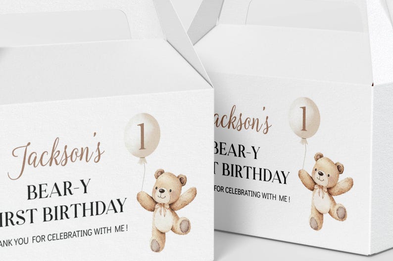 May include: Two white cardboard gable boxes featuring a printed illustration of a light brown teddy bear holding a beige balloon with the number one. The text reads Jackson's BEAR-Y FIRST BIRTHDAY THANK YOU FOR CELEBRATING WITH ME!