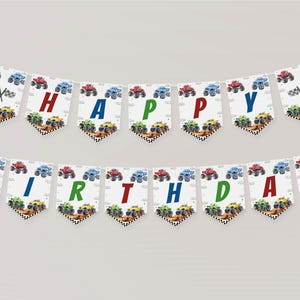May include: A white and blue birthday banner with monster trucks and the words "Happy Birthday" in colorful letters.