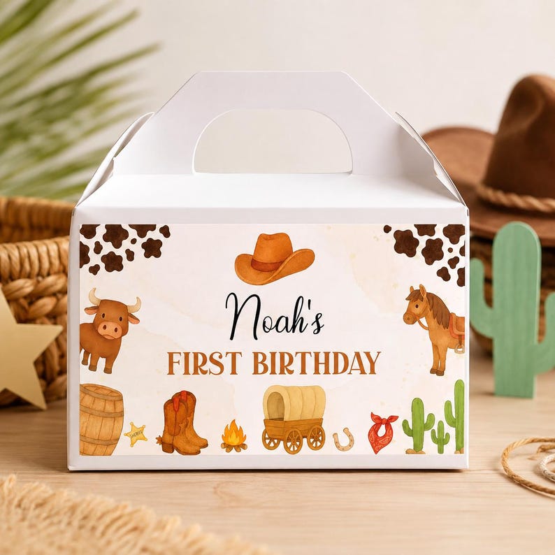 Puede incluir: Una caja de cart&oacute;n blanca con asa, decorada con un dise&ntilde;o de tem&aacute;tica western y manchas de vaca marrones en las esquinas. Incluye un sombrero de vaquero, un toro, un caballo, un barril, botas, una fogata, una carreta, un pa&ntilde;uelo y cactus con el texto Noah's FIRST BIRTHDAY.