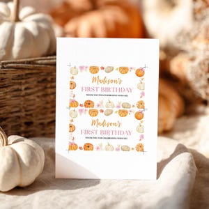 May include: A white rectangular card featuring two identical printed labels with the text Madison's FIRST BIRTHDAY THANK YOU FOR CELEBRATING WITH ME! The labels are decorated with a border of watercolor pumpkins, pink flowers, and gold stars.
