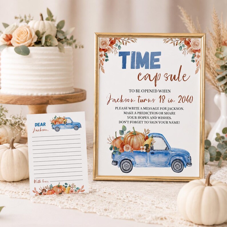 May include: A gold-framed sign and a matching card featuring a blue truck, pumpkins, and floral accents. The sign reads: TIME capsule TO BE OPENED WHEN Jackson turns 18 in 2040. PLEASE WRITE A MESSAGE FOR JACKSON. MAKE A PREDICTION OR SHARE YOUR HOPES AND WISHES.